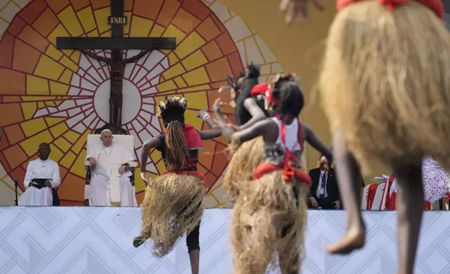 FILE - Pope Francis, second from left, looks at traditional dancers performing at the Martyrs' Stadium In Kinshasa, Democratic Republic of Congo, Thursday, Feb. 2, 2023. (AP Photo/Gregorio Borgia, file)