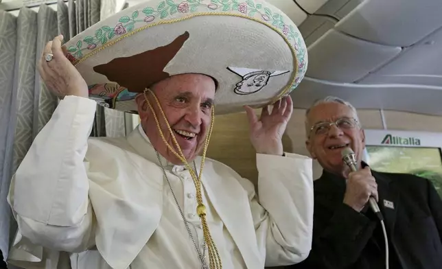 FILE - Pope Francis wears a traditional Mexican sombrero hat he received as a gift by a Mexican journalist aboard the plane during the flight from Rome to Habana, Cuba, on his way to a week-long trip to Mexico, Friday, Feb. 12, 2016. (Alessandro Di Meo/Pool Photo via AP, File)
