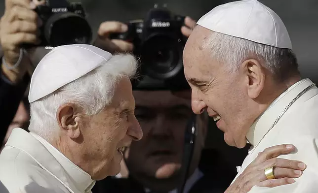 FILE - Pope Francis, right, hugs Emeritus Pope Benedict XVI prior to the start of a meeting with elderly faithful in St. Peter's Square at the Vatican on Sept. 28, 2014. (AP Photo/Gregorio Borgia, File)