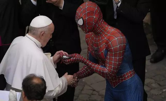 FILE - Pope Francis meets Spider-Man, who presents him with his mask, at the end of his weekly general audience with a limited number of faithful in the San Damaso Courtyard at the Vatican, Wednesday, June 23, 2021. (AP Photo/Andrew Medichini, file)