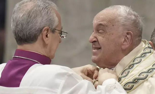 FILE - Pope Francis is helped by Vatican Master of Ceremonies, Bishop Diego Giovanni Ravelli, left, as he arrives for a mass in St. Peter's Basilica at The Vatican on New Year's Day, Wednesday, Jan. 1, 2025. (AP Photo/Andrew Medichini, File)