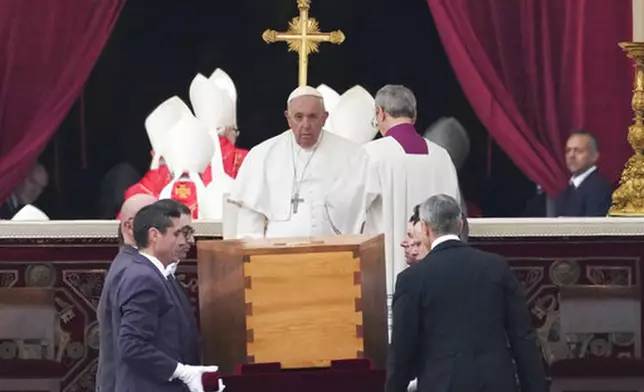 FILE - Pope Francis, center, sits as the coffin of late Pope Emeritus Benedict XVI is carried in St. Peter's Square for his funeral mass, at the Vatican, Thursday, Jan. 5, 2023. (AP Photo/Alessandra Tarantino, File)