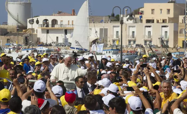 FILE - Pope Francis waves to faithful as he is driven through the crowd during his visit to the island of Lampedusa, southern Italy, Monday July 8, 2013. (AP Photo/Alessandra Tarantino, file)