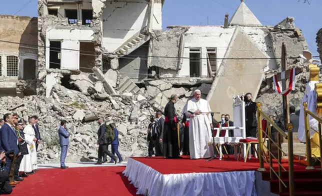 FILE - Pope Francis, surrounded by shells of destroyed churches, leads a prayer for the victims of war at Hosh al-Bieaa Church Square, in Mosul, Iraq, once the de-facto capital of IS, Sunday, March 7, 2021. (AP Photo/Andrew Medichini, file)