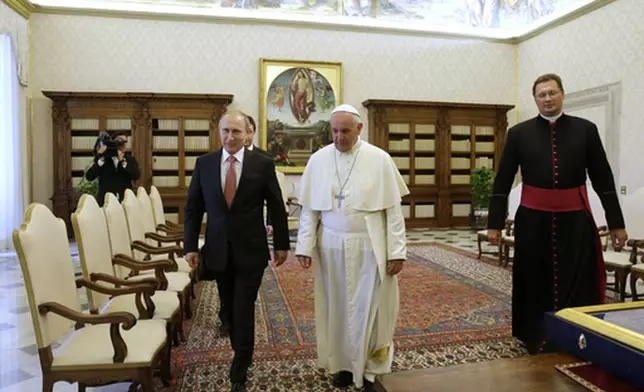 FILE - Pope Francis walks next to Russian President Vladimir Putin on the occasion of their private audience at the Vatican, Wednesday, June 10, 2015. (AP Photo/Gregorio Borgia, Pool, file)