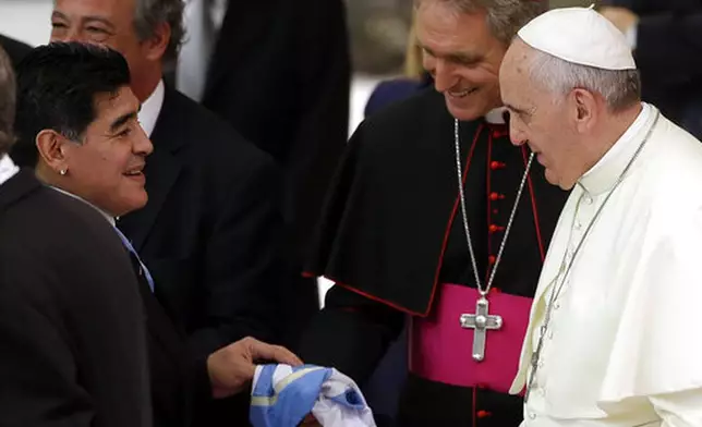 FILE - Argentine soccer legend Diego Armando Maradona, left, greets Pope Francis in the Paul VI hall at the Vatican, Monday, Sept. 1, 2014. (AP Photo/Gregorio Borgia, File)