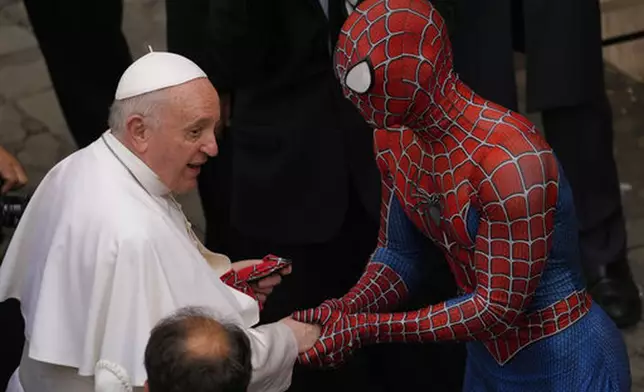 FILE - Pope Francis meets a man wearing a Spider-Man costume, who presented him with his mask, at the end of his weekly general audience with a limited number of faithful in the San Damaso Courtyard at the Vatican, Wednesday, June 23, 2021. (AP Photo/Andrew Medichini, file)