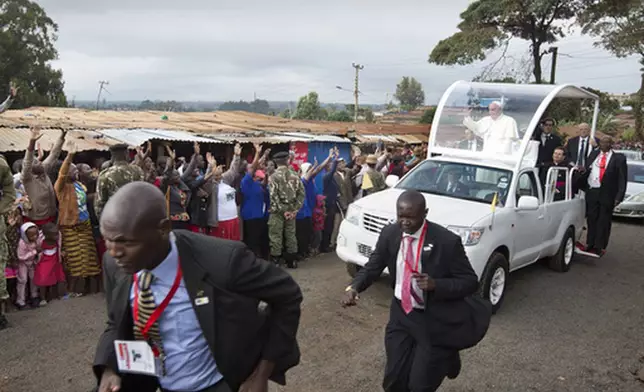 FILE - Pope Francis waves to local residents as he drives to St. Joseph The Worker Catholic Church in the Kangemi slum of Nairobi, Kenya, Friday, Nov. 27, 2015. (AP Photo/Ben Curtis, file)