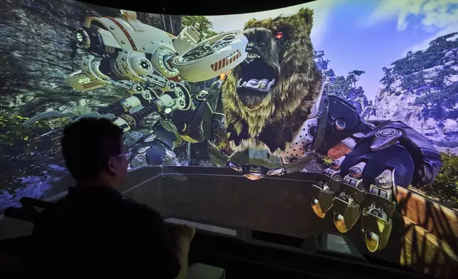 A man experience a 3D ride at the experience center of Zhuoyuan Tech Co., Ltd in Panyu district of Guangzhou city in southern China's Guangdong province on Wednesday, April 16, 2025. (AP Photo/Ng Han Guan)