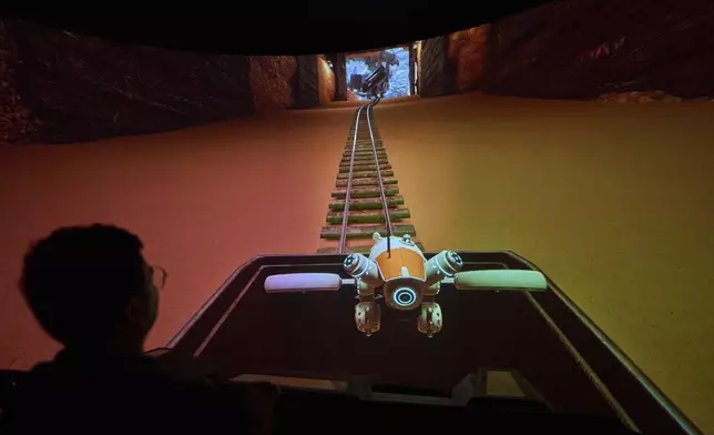 A man experience a 3D ride at the experience center of Zhuoyuan Tech Co., Ltd in Panyu district of Guangzhou city in southern China's Guangdong province on Wednesday, April 16, 2025. (AP Photo/Ng Han Guan)