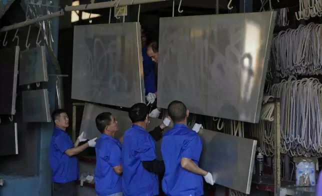 Workers prepare aluminum panels for coating at a factory of Kam Pin Industrial (HK) Ltd, in Dongguan city in southern China's Guangdong province on Thursday, April 17, 2025. (AP Photo/Ng Han Guan)