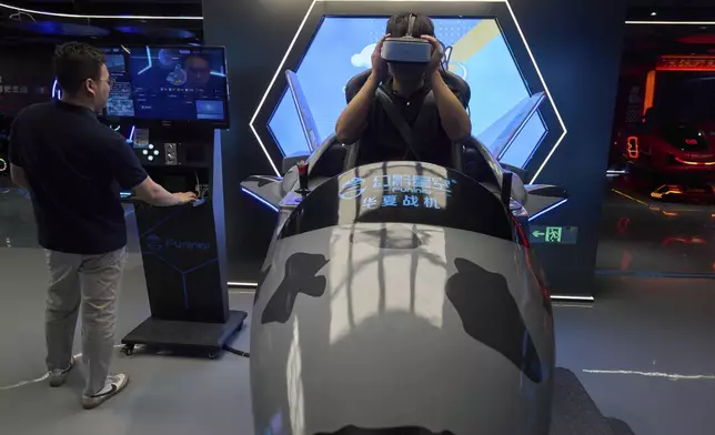 A worker tries out a virtual reality platform at the experience center of Zhuoyuan Tech Co., Ltd in Panyu district of Guangzhou city in southern China's Guangdong province on Wednesday, April 16, 2025. (AP Photo/Ng Han Guan)