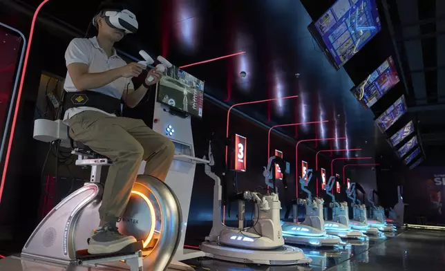 A worker tries out a virtual reality platform at the experience center of Zhuoyuan Tech Co., Ltd in Panyu district of Guangzhou city in southern China's Guangdong province on Wednesday, April 16, 2025. (AP Photo/Ng Han Guan)
