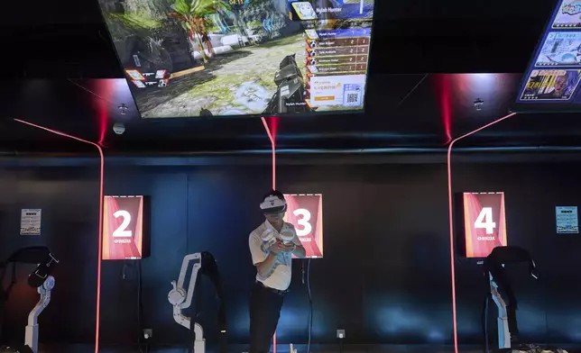 A man tries out a virtual reality game at the experience center of Zhuoyuan Tech Co., Ltd in Panyu district of Guangzhou city in southern China's Guangdong province on Wednesday, April 16, 2025. (AP Photo/Ng Han Guan)