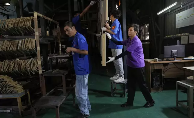 Workers check aluminum panels produced at a factory of Kam Pin Industrial (HK) Ltd, in Dongguan city in southern China's Guangdong province on Thursday, April 17, 2025. (AP Photo/Ng Han Guan)