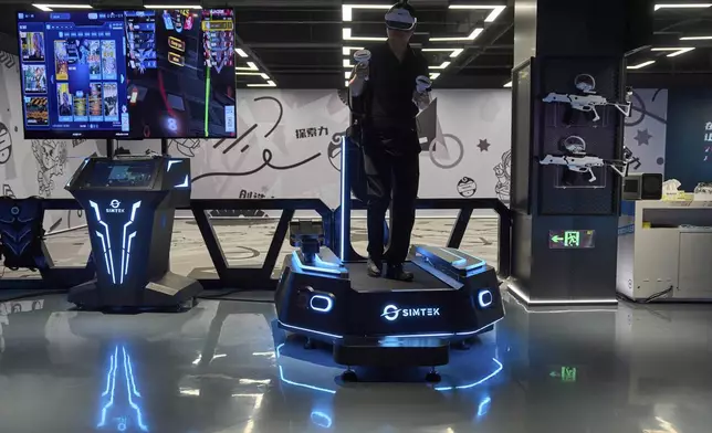 A man tries out a virtual reality platform at the experience center of Zhuoyuan Tech Co., Ltd in Panyu district of Guangzhou city in southern China's Guangdong province on Wednesday, April 16, 2025. (AP Photo/Ng Han Guan)
