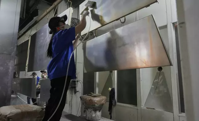A worker prepares aluminum panels for coating at a factory of Kam Pin Industrial (HK) Ltd, in Dongguan city in southern China's Guangdong province on Thursday, April 17, 2025. (AP Photo/Ng Han Guan)