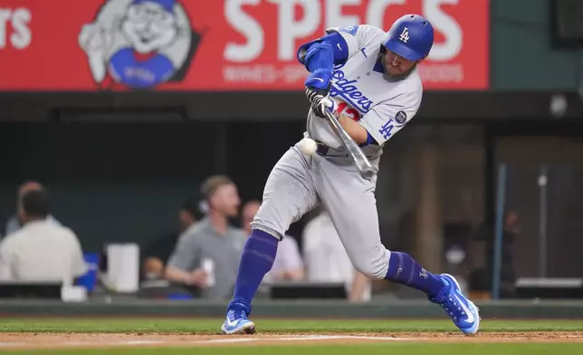 Los Angeles Dodgers' Max Muncy connects for a single against the Texas Rangers during the second inning of a baseball game Friday, April 18, 2025, in Arlington, Texas. (AP Photo/Julio Cortez)