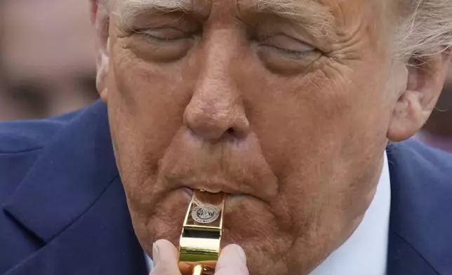 President Donald Trump blows a gold plated whistle with the presidential seal, during the White House Easter Egg Roll on the South Lawn of the White House, Monday, April 21, 2025, in Washington. (AP Photo/Alex Brandon)