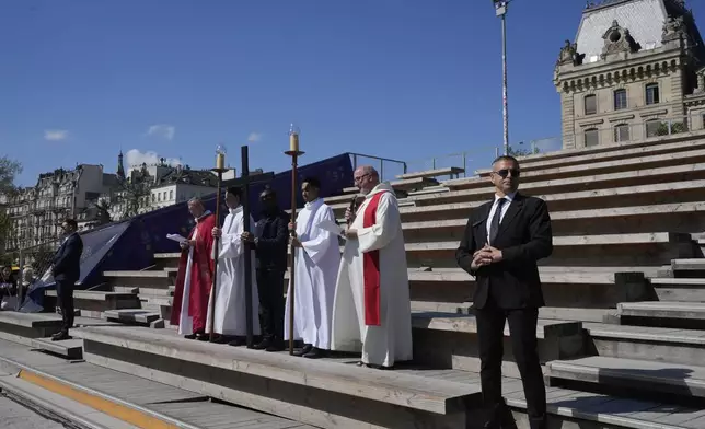 Clergymen stop during the Way of Cross ceremony to mark Good Friday at Notre Dame cathedral, Friday, April 18, 2025 in Paris. (AP Photo/Michel Euler)