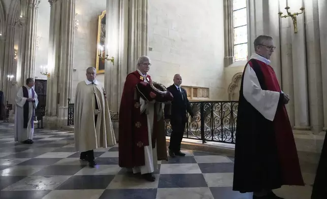 Paris Archbishop Laurent Ulrich, center, holds the ancient relic that many Christians revere as Jesus Christ's "Crown of Thorns" during a ceremony to mark Good Friday at Notre Dame cathedral, Friday, April 18, 2025 in Paris. (AP Photo/Michel Euler)