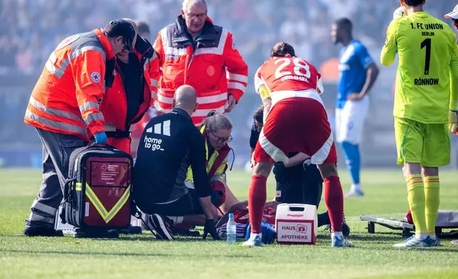Berlin's Diogo Leite receives medical treatment during the German Bundesliga soccer match between VfL Bochum and 1. FC Union Berlin in Bochum, Germany, Sunday, April 27, 2025. (David Inderlied/dpa via AP)