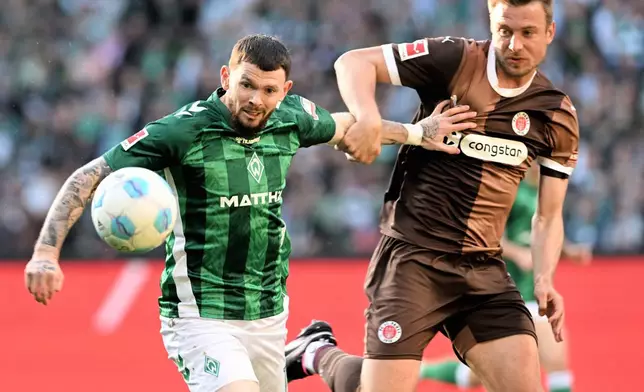 Werder's Oliver Burke, left, and Pauli's Hauke Wahl, right, challenge for the ball during the German Bundesliga soccer match between Werder Bremen and FC St. Pauli in Bremen, Germany, Sunday, April 27, 2025. (Carmen Jaspersen/dpa via AP)