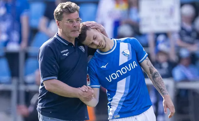 Bochum's head coach Dieter Hecking, left, comforts Bochum's Tom Krauß, right, after the German Bundesliga soccer match between VfL Bochum and 1. FC Union Berlin in Bochum, Germany, Sunday, April 27, 2025. (David Inderlied/dpa via AP)