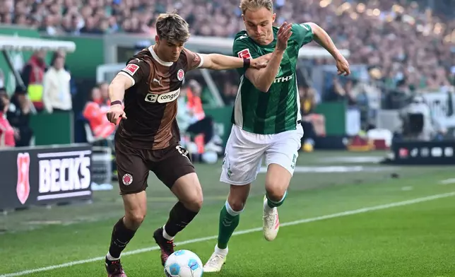 Werder's Amos Pieper, right, and Pauli's Noah Weisshaupt, left, challenge for the ball during the German Bundesliga soccer match between Werder Bremen and FC St. Pauli in Bremen, Germany, Sunday, April 27, 2025. (Carmen Jaspersen/dpa via AP)