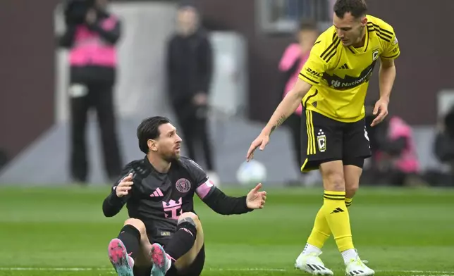 Columbus Crew midfielder Daniel Gazdag, right, reaches out to Inter Miami CF forward Lionel Messi during the first half of an MLS soccer match on Saturday, April 19, 2025, in Cleveland, Ohio. (AP Photo/David Richard)