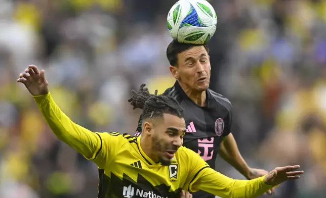 Inter Miami midfielder Tadeo Allende, top, heads the ball over Columbus Crew defender Mohamed Farsi, bottom, during the first half of an MLS soccer match Saturday, April 19, 2025, in Cleveland, Ohio. (AP Photo/David Richard)