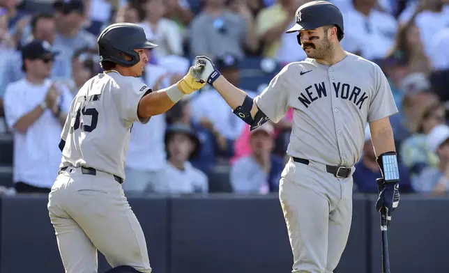 New York Yankees' Oswaldo Cabrera, left, celebrates after scoring against the Tampa Bay Rays with Austin Wells during the fourth inning of a baseball game Saturday, April 19, 2025, in Tampa, Fla. (AP Photo/Mike Carlson)
