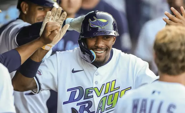 Tampa Bay Rays' Chandler Simpson is congratulated after scoring during the ninth inning of a baseball game against the New York Yankees, Saturday, April 19, 2025, in Tampa, Fla. (AP Photo/Mike Carlson)