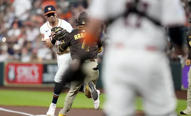 San Diego Padres' Luis Arraez (4) collides with Houston Astros second baseman Mauricio Dubon, left, at first base resulting in Arraez being carted off the field during the first inning of a baseball game Sunday, April 20, 2025, in Houston. (AP Photo/Karen Warren)