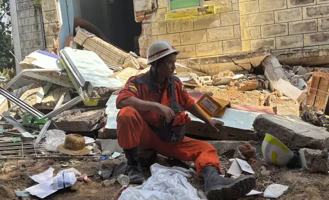A rescuer rests near a damaged building following Friday's earthquake in Naypyitaw, Myanmar, Thursday, April 3, 2025. (AP Photo)