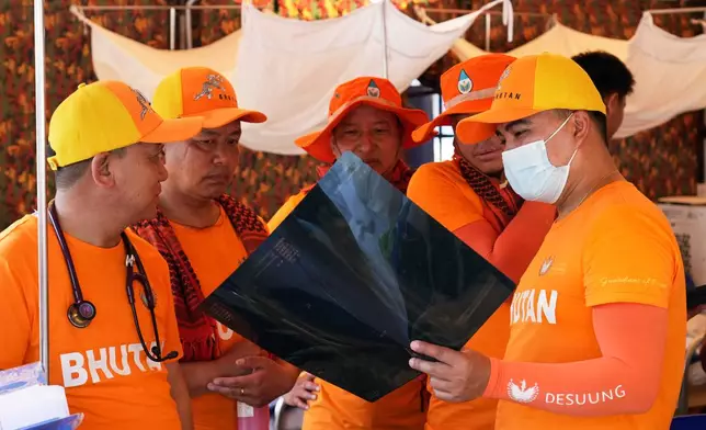Bhutanese medical volunteers look at the chest scan of a patient at a make-shift tent after last week's earthquake in Naypyitaw, Myanmar, Friday, April 4, 2025. (AP Photo)