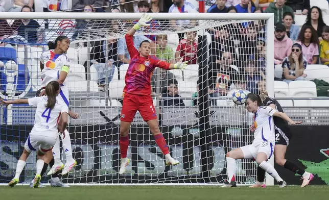 Lyon's Damaris Egurrola, 2nd right, heads the ball before Lyon goalkeeper Christiane Endler deflects the ball into her own goal to give Arsenal the opening goal during the women's Champions League semifinals, second leg, soccer match between Olympique Lyonnais and Arsenal at OL Stadium in Decines, outside Lyon, France, Sunday, April 27, 2025. (AP Photo/Thibault Camus)