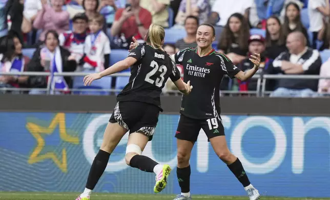 Arsenal's Alessia Russo celebrates with Caitlin Foord, right, after scoring her side's third goal during the women's Champions League semifinals, second leg, soccer match between Olympique Lyonnais and Arsenal at OL Stadium in Decines, outside Lyon, France, Sunday, April 27, 2025. (AP Photo/Thibault Camus)