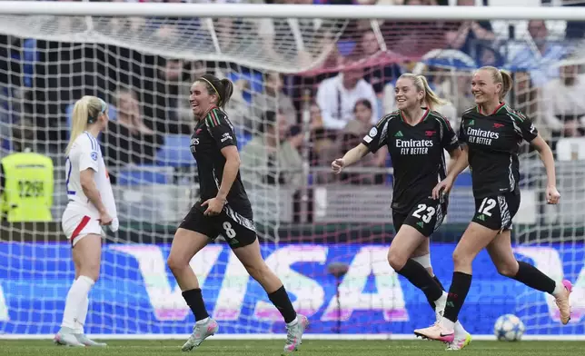 Arsenal's Mariona Caldentey, left, celebrates after scoring her side's second goal during the women's Champions League semifinals, second leg, soccer match between Olympique Lyonnais and Arsenal at OL Stadium in Decines, outside Lyon, France, Sunday, April 27, 2025. (AP Photo/Thibault Camus)