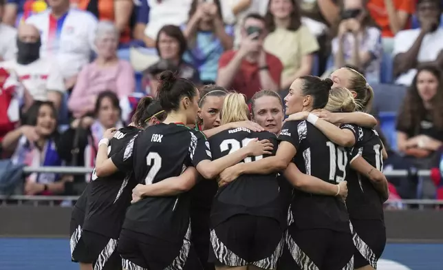 Arsenal's Alessia Russo, back to camera, celebrates after scoring her side's third goal during the women's Champions League semifinals, second leg, soccer match between Olympique Lyonnais and Arsenal at OL Stadium in Decines, outside Lyon, France, Sunday, April 27, 2025. (AP Photo/Thibault Camus)