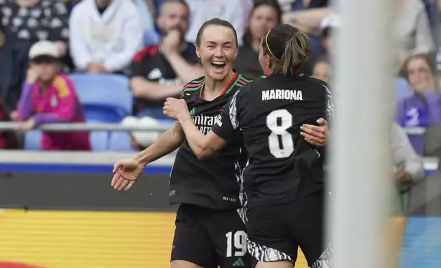 Arsenal's Caitlin Foord celebrates with Mariona Caldentey after scoring her side's fourth goal during the women's Champions League semifinals, second leg, soccer match between Olympique Lyonnais and Arsenal at OL Stadium in Decines, outside Lyon, France, Sunday, April 27, 2025. (AP Photo/Thibault Camus)