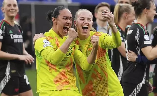 Arsenal goalkeepers Manuela Zinsberger, left, and Daphne van Domselaar celebrate after defeating Lyon 4-1 in their women's Champions League semifinals, second leg, soccer match at OL Stadium in Decines, outside Lyon, France, Sunday, April 27, 2025. (AP Photo/Thibault Camus)