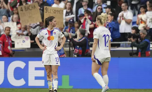 Lyon's Damaris Egurrola and Ellie Carpenter, right, react at the end the women's Champions League semifinals, second leg, soccer match between Olympique Lyonnais and Arsenal at OL Stadium in Decines, outside Lyon, France, Sunday, April 27, 2025. (AP Photo/Thibault Camus)
