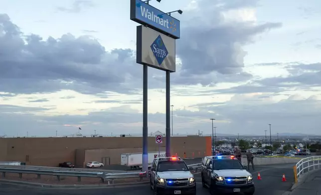 FILE - In this Aug. 3, 2019, photo Texas state police cars block the access to the Walmart store in the aftermath of a mass shooting in El Paso, Texas. (AP Photo/Andres Leighton, File)
