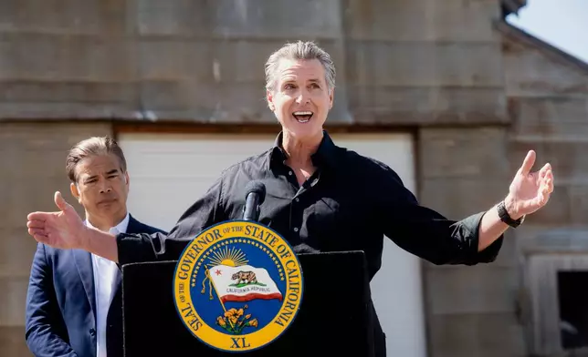 California Gov. Gavin Newsom discusses President Donald Trump's tariffs, as California Attorney General Rob Bonta, left, listens, during a press conference on Wednesday, April 16, 2025, at an almond farm in Ceres, Calif. (AP Photo/Noah Berger)