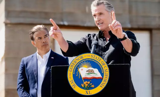 California Gov. Gavin Newsom discusses President Donald Trump's tariffs, as California Attorney General Rob Bonta, left, listens, during a press conference on Wednesday, April 16, 2025, at an almond farm in Ceres, Calif. (AP Photo/Noah Berger)