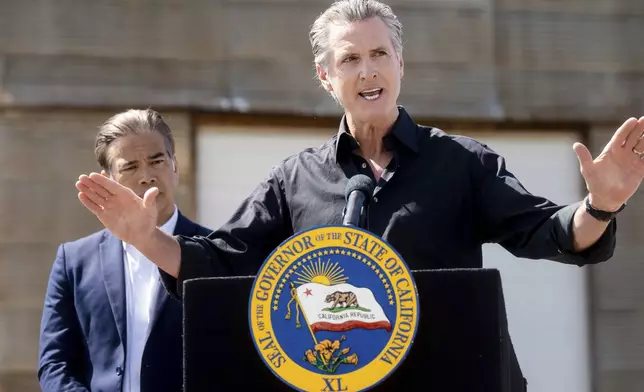 California Gov. Gavin Newsom discusses President Donald Trump's tariffs, as California Attorney General Rob Bonta, left, listens, during a press conference on Wednesday, April 16, 2025, at an almond farm in Ceres, Calif. (AP Photo/Noah Berger)