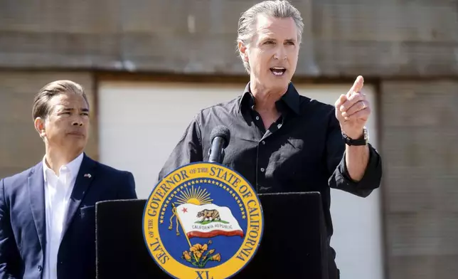 California Gov. Gavin Newsom discusses President Donald Trump's tariffs, as California Attorney General Rob Bonta, left, listens, during a press conference on Wednesday, April 16, 2025, at an almond farm in Ceres, Calif. (AP Photo/Noah Berger)