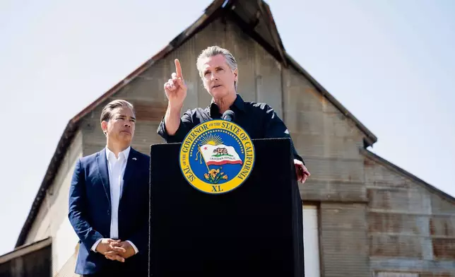 California Gov. Gavin Newsom discusses President Donald Trump's tariffs, as California Attorney General Rob Bonta, left, listens, during a press conference on Wednesday, April 16, 2025, at an almond farm in Ceres, Calif. (AP Photo/Noah Berger)