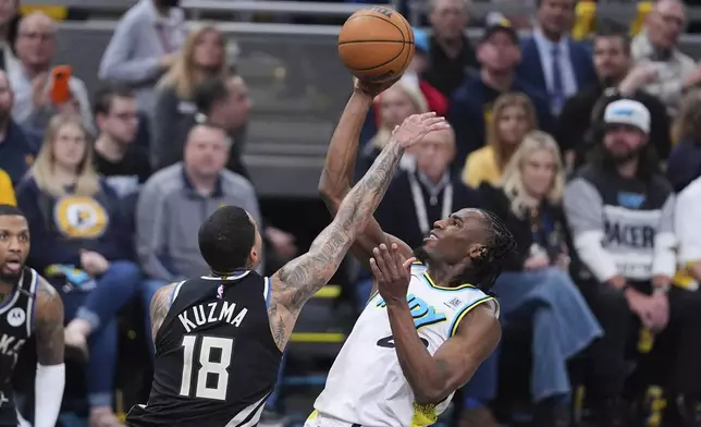 Indiana Pacers forward Aaron Nesmith (23) shoots over Milwaukee Bucks forward Kyle Kuzma (18) during the second half of a first-round NBA basketball playoff game in Indianapolis, Tuesday, April 22, 2025. (AP Photo/Michael Conroy)